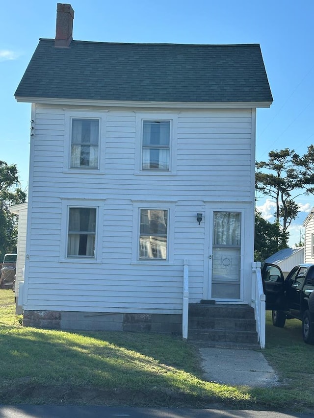 3529 Ridge Rd, Chincoteague, VA 23336 - view of front of home with entry steps, a chimney, a front yard, and roof with shingles