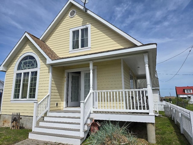 view of front of property with a porch and fence