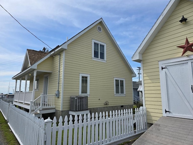 back of property featuring covered porch, central AC, and fence private yard