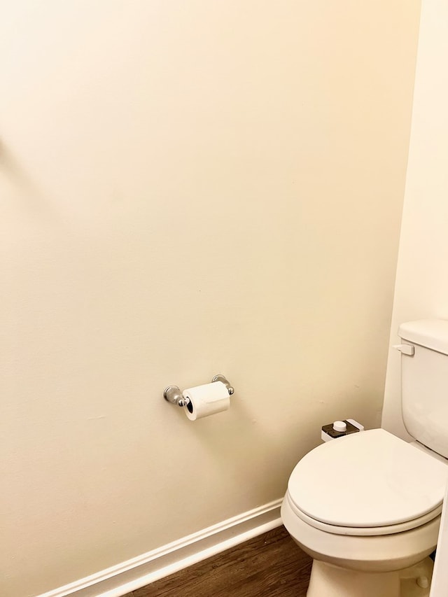 bathroom with hardwood / wood-style flooring and toilet