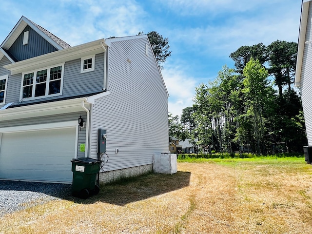 view of side of home with a yard and a garage