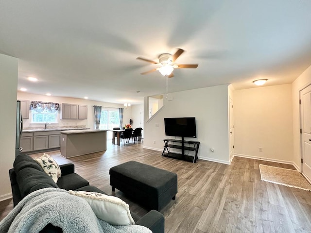 living room with ceiling fan, sink, and light hardwood / wood-style floors