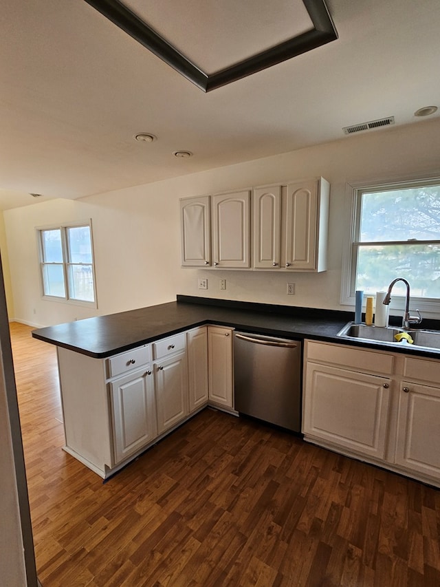 kitchen featuring sink, white cabinetry, stainless steel dishwasher, dark hardwood / wood-style flooring, and kitchen peninsula