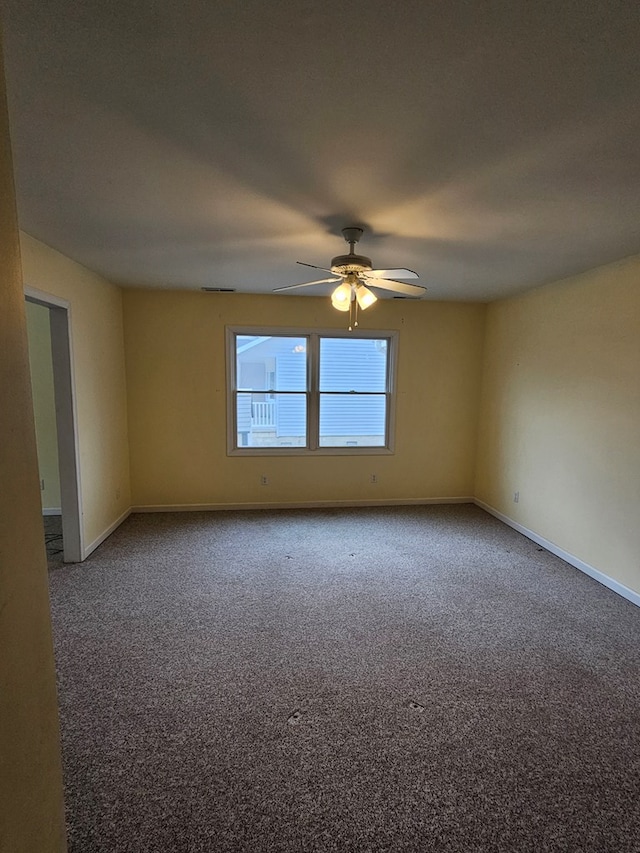 empty room with a ceiling fan, baseboards, and carpet floors