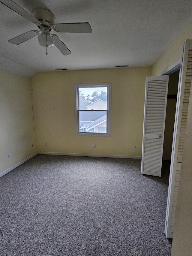 unfurnished bedroom with ceiling fan, lofted ceiling, carpet flooring, and a textured ceiling