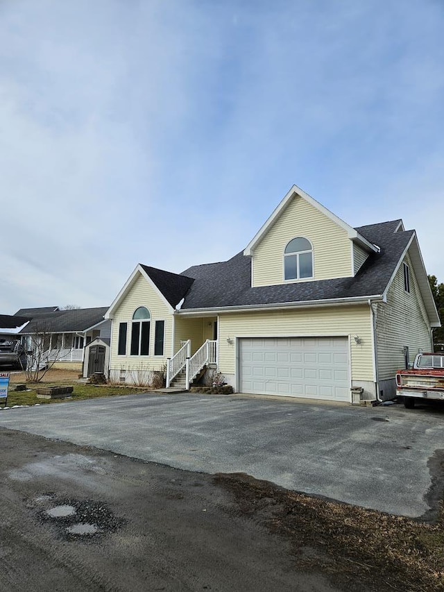 view of front of home featuring aphalt driveway, a shingled roof, and a garage