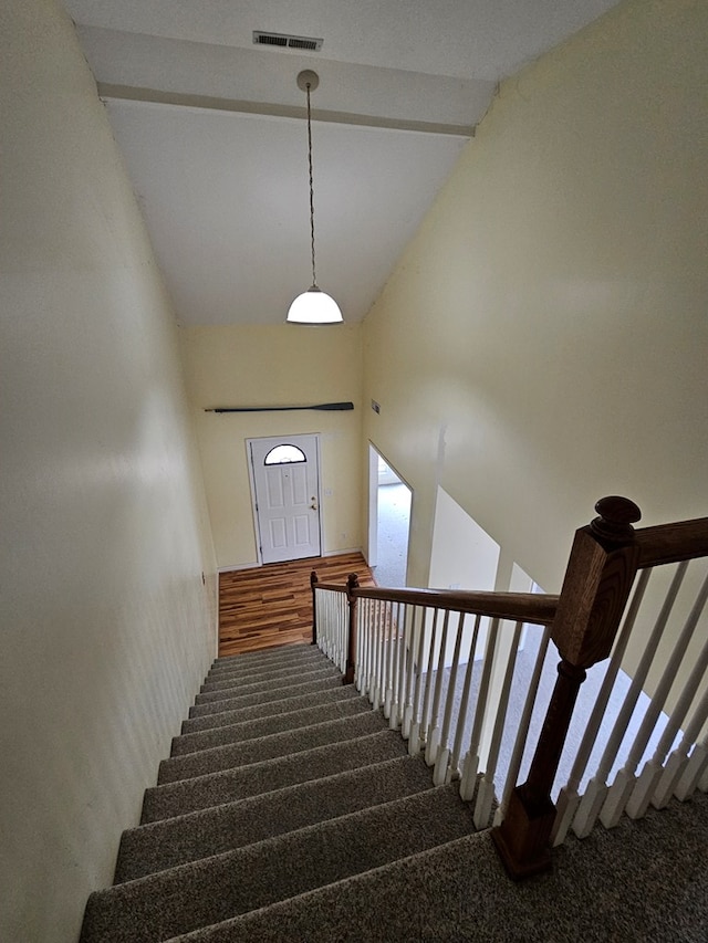 stairs featuring carpet floors and high vaulted ceiling