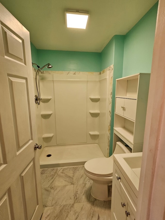 bathroom with curtained shower, vanity, toilet, and marble finish floor