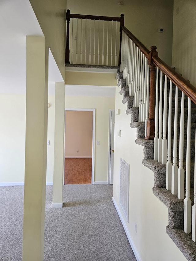 stairs featuring visible vents, baseboards, and carpet