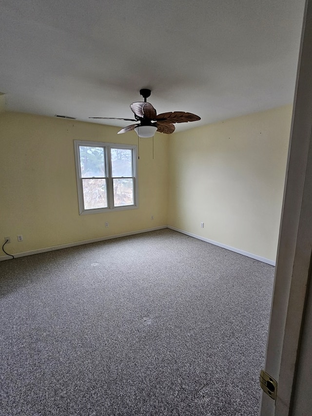 spare room featuring carpet, baseboards, and ceiling fan