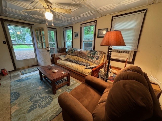 carpeted living room with ceiling fan and cooling unit