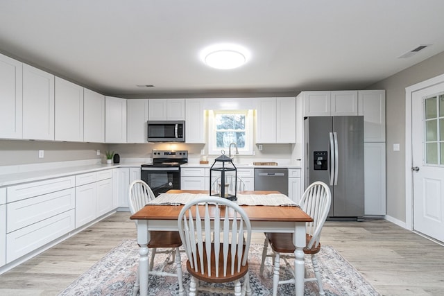 kitchen featuring white cabinetry, light hardwood / wood-style flooring, and stainless steel appliances