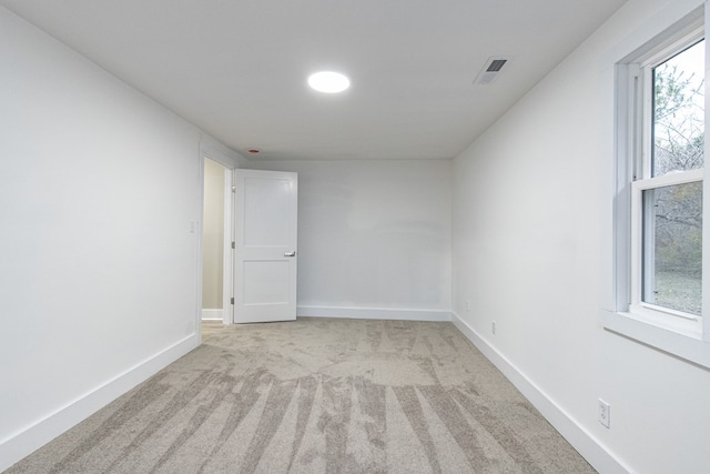 unfurnished room featuring light carpet