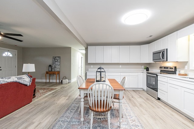 kitchen with white cabinets, ceiling fan, light wood-type flooring, and appliances with stainless steel finishes