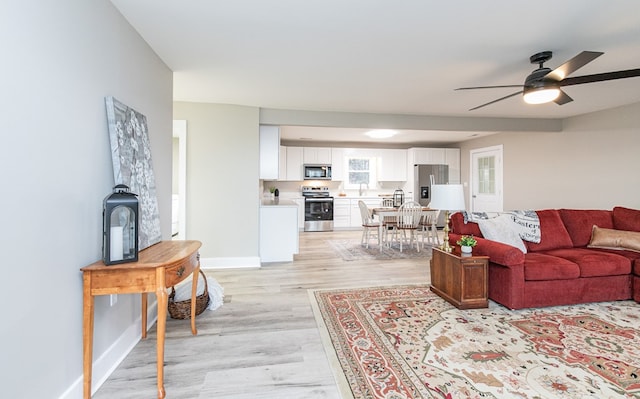 living room featuring light wood-type flooring and ceiling fan