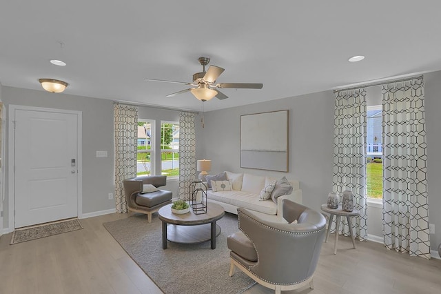 living area with light wood-style floors, recessed lighting, ceiling fan, and baseboards