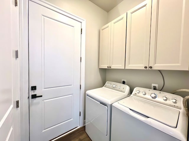 laundry room with washer and dryer, cabinets, and dark wood-type flooring