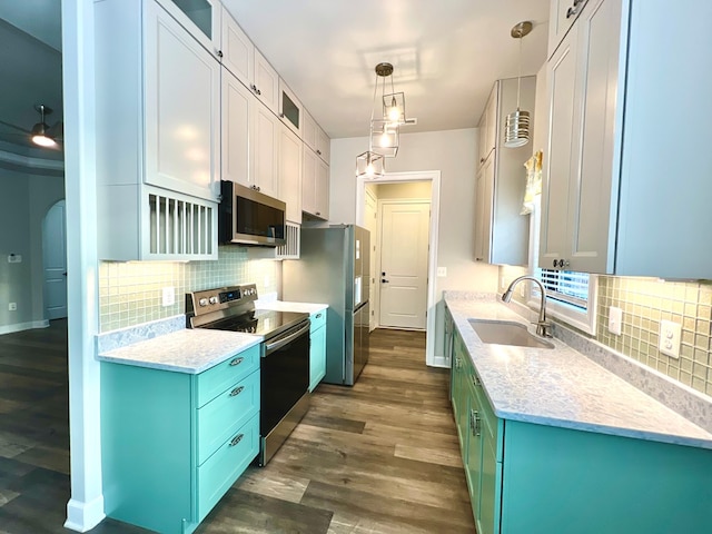 kitchen with appliances with stainless steel finishes, dark wood-type flooring, sink, decorative light fixtures, and white cabinets