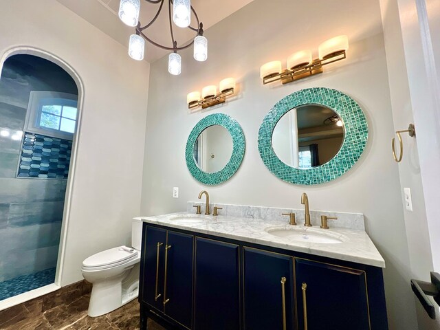 bathroom featuring tiled shower, vanity, and toilet