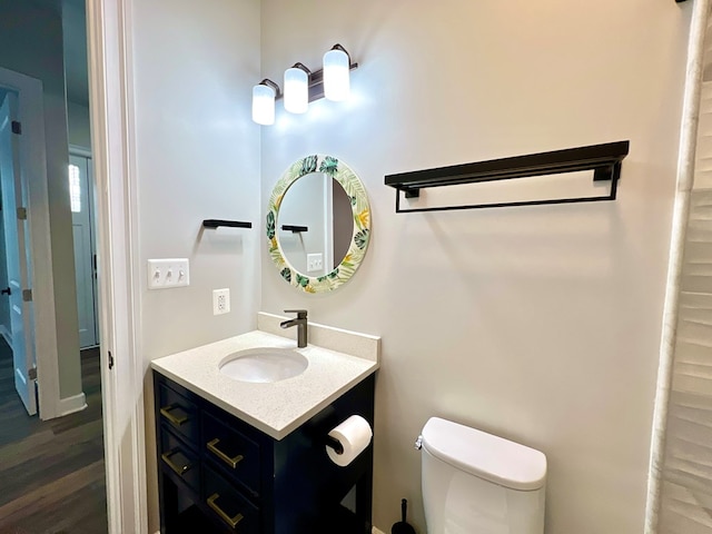 bathroom with vanity, hardwood / wood-style flooring, and toilet