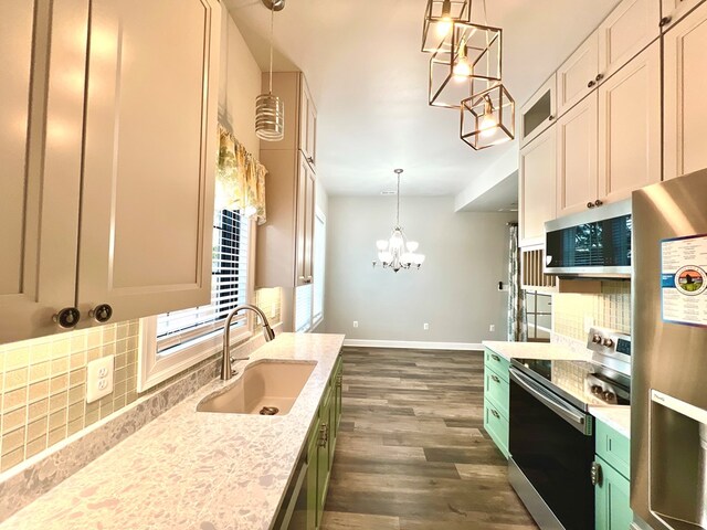 kitchen with backsplash, sink, hanging light fixtures, light stone counters, and stainless steel appliances