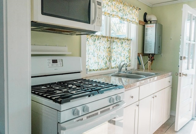 kitchen featuring light countertops, water heater, white cabinetry, a sink, and white appliances