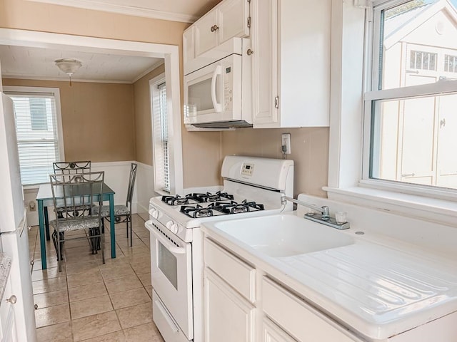 kitchen featuring light countertops, white appliances, white cabinets, and crown molding