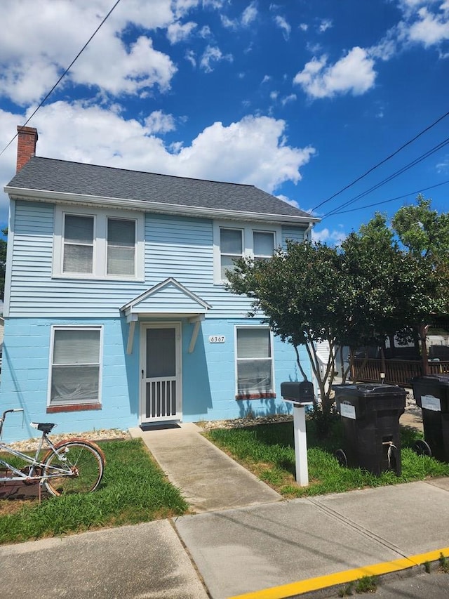 townhome / multi-family property featuring roof with shingles and a chimney