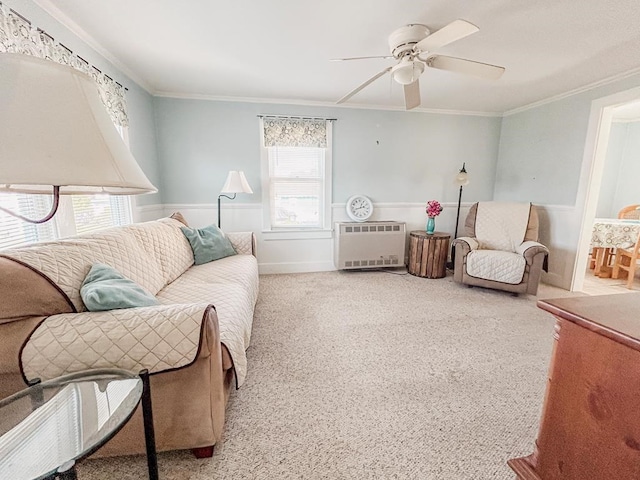 living area with ceiling fan, carpet floors, heating unit, and crown molding