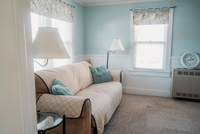 living area featuring carpet floors, ornamental molding, wainscoting, and radiator