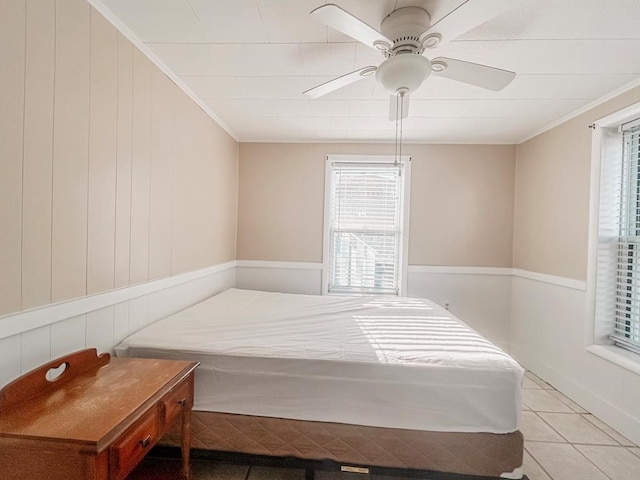 bedroom with tile patterned flooring, crown molding, and ceiling fan