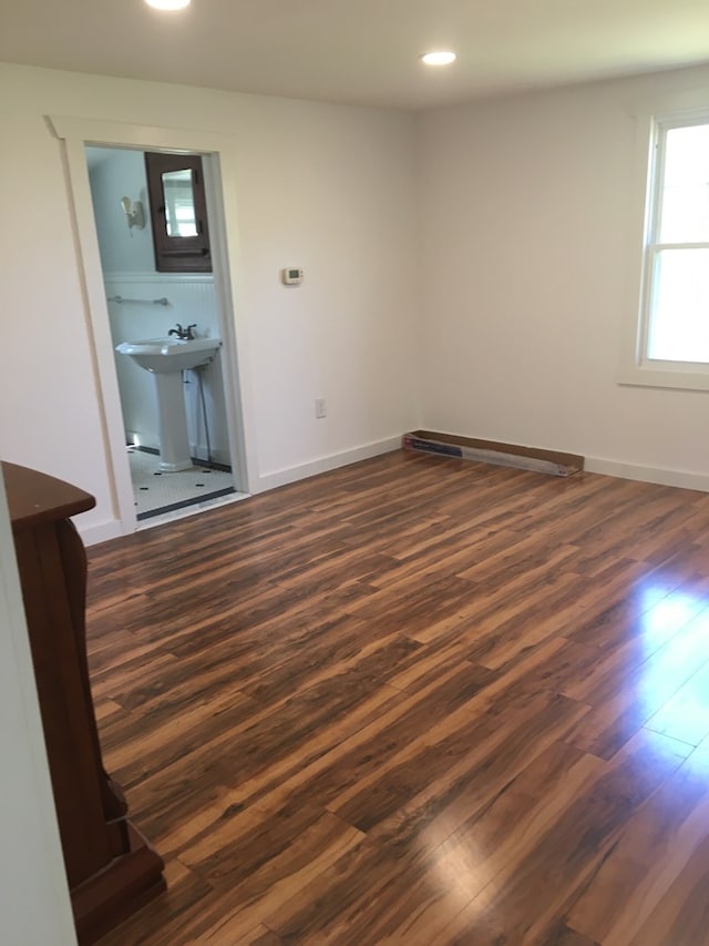 empty room with dark hardwood / wood-style flooring and sink