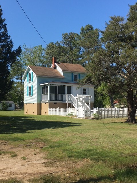 rear view of house with a sunroom and a lawn