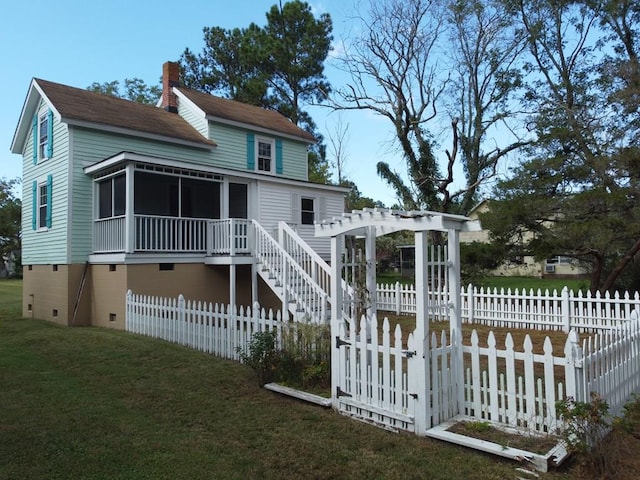 back of property featuring a sunroom, a pergola, and a yard