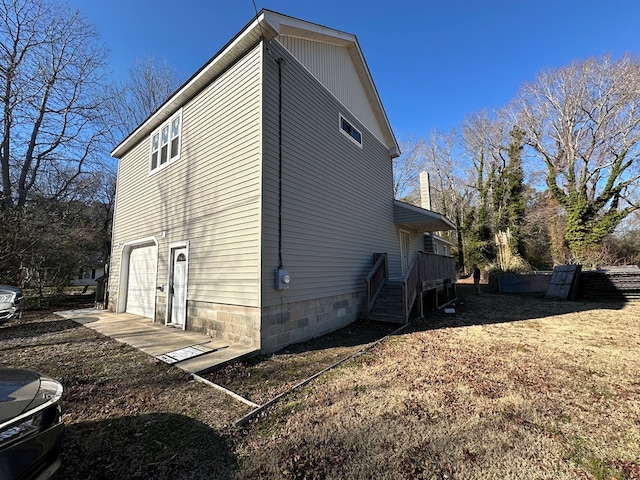 view of home's exterior featuring a wooden deck and a garage