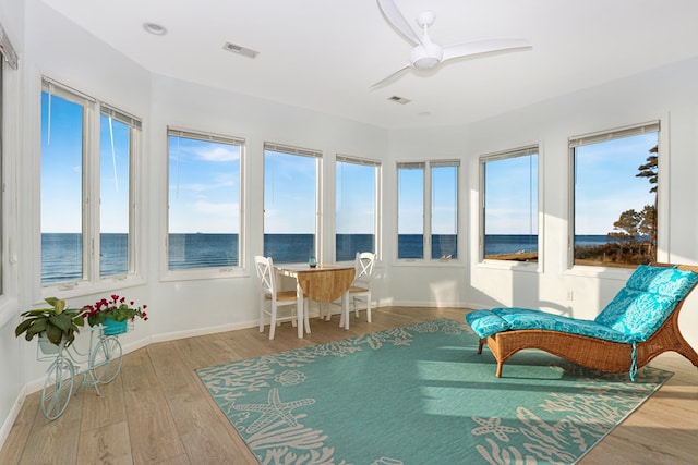 sunroom / solarium featuring a ceiling fan, visible vents, and a wealth of natural light