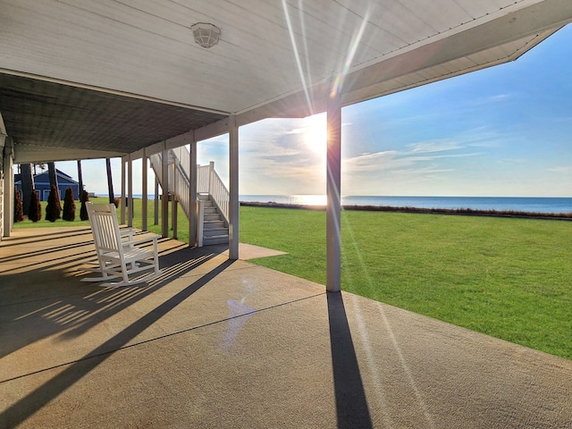 view of patio with stairs and a water view