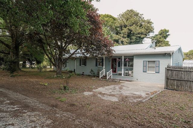 8045 Hickman Farm Ln, Wallops Island, VA 23337 - rear view of property with fence, covered porch, and metal roof