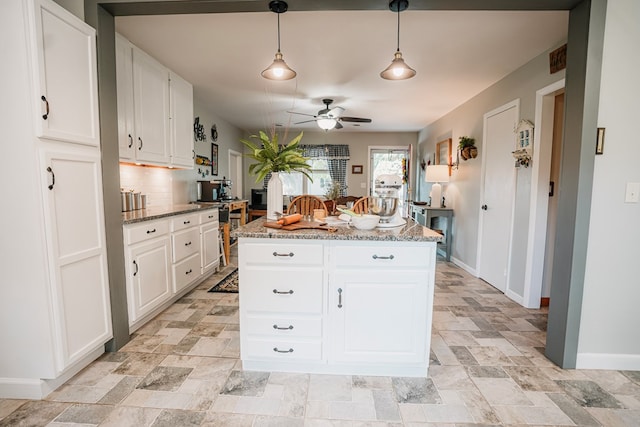 8045 Hickman Farm Ln, Wallops Island, VA 23337 - kitchen with baseboards, a center island, backsplash, and white cabinetry