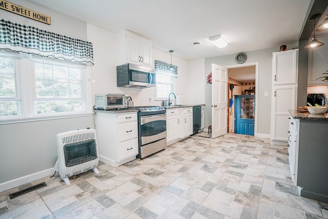 8045 Hickman Farm Ln, Wallops Island, VA 23337 - kitchen with decorative backsplash, visible vents, a sink, heating unit, and stainless steel appliances