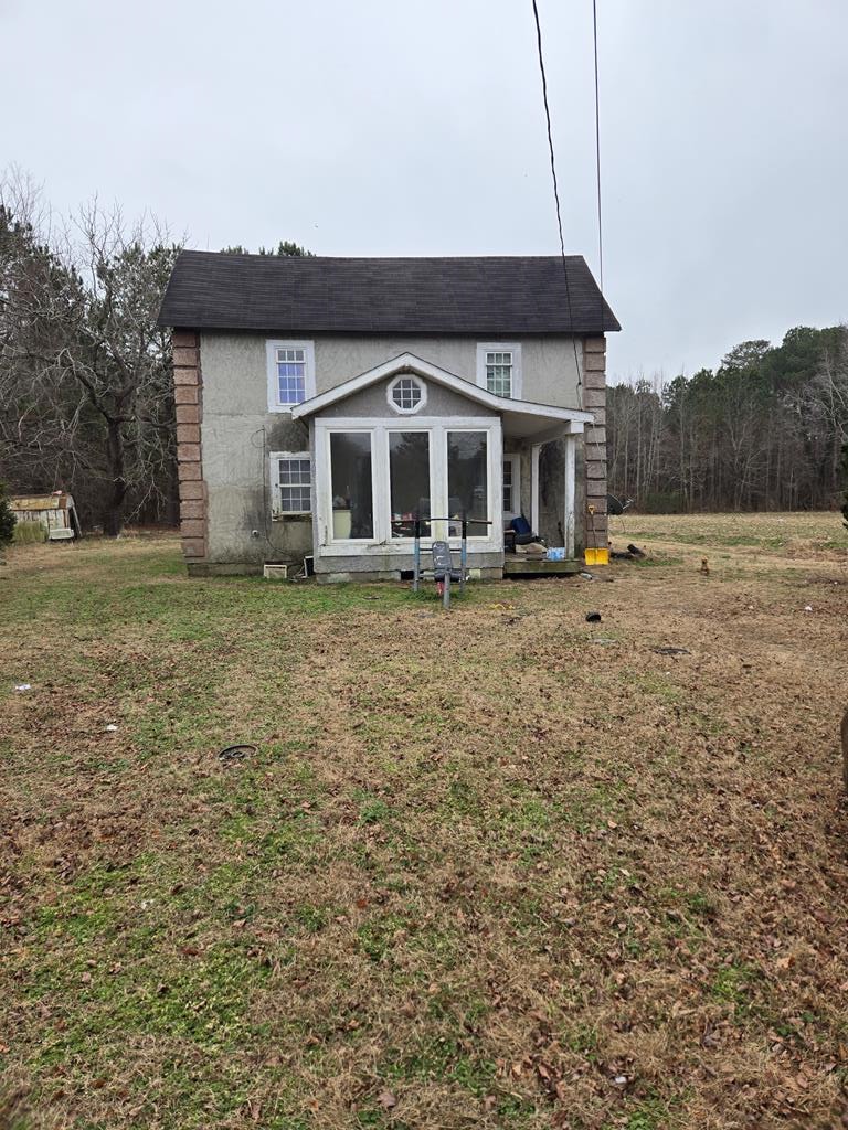 back of house with a lawn