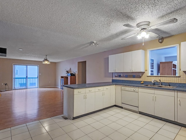 kitchen with dishwasher, sink, backsplash, kitchen peninsula, and light tile patterned floors