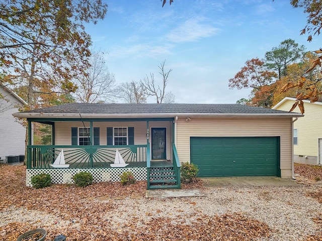 ranch-style house featuring covered porch, a garage, and central air condition unit