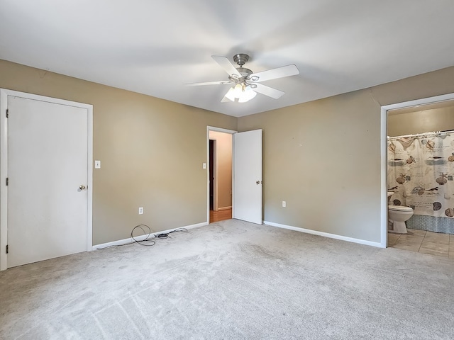 unfurnished bedroom featuring connected bathroom, light colored carpet, and ceiling fan