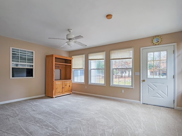 unfurnished living room with ceiling fan and light colored carpet