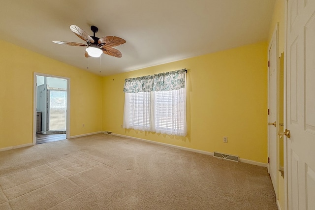 empty room featuring light colored carpet, visible vents, and baseboards