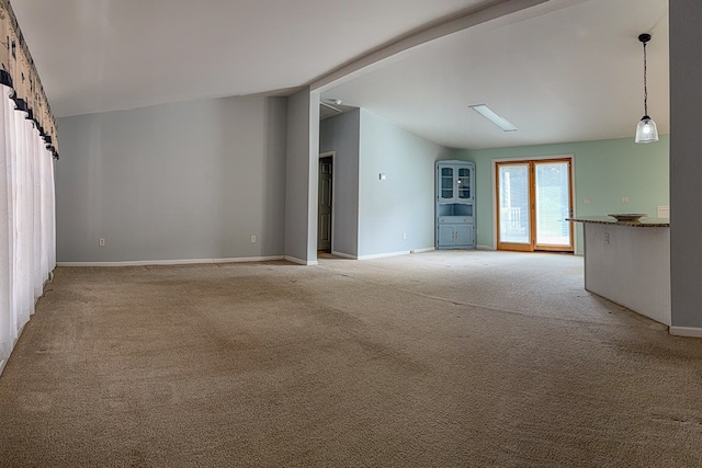 spare room with vaulted ceiling, light carpet, and baseboards