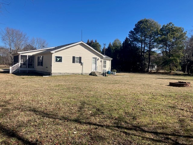 view of side of property with entry steps, a sunroom, and a yard