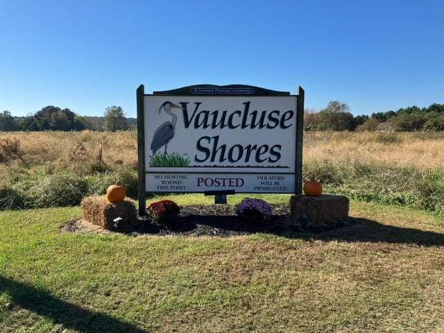 community / neighborhood sign with a yard and a rural view