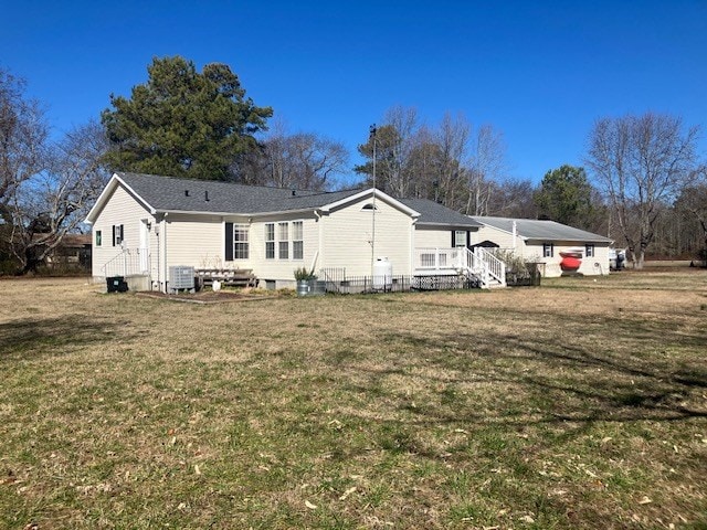 back of house featuring central AC and a yard